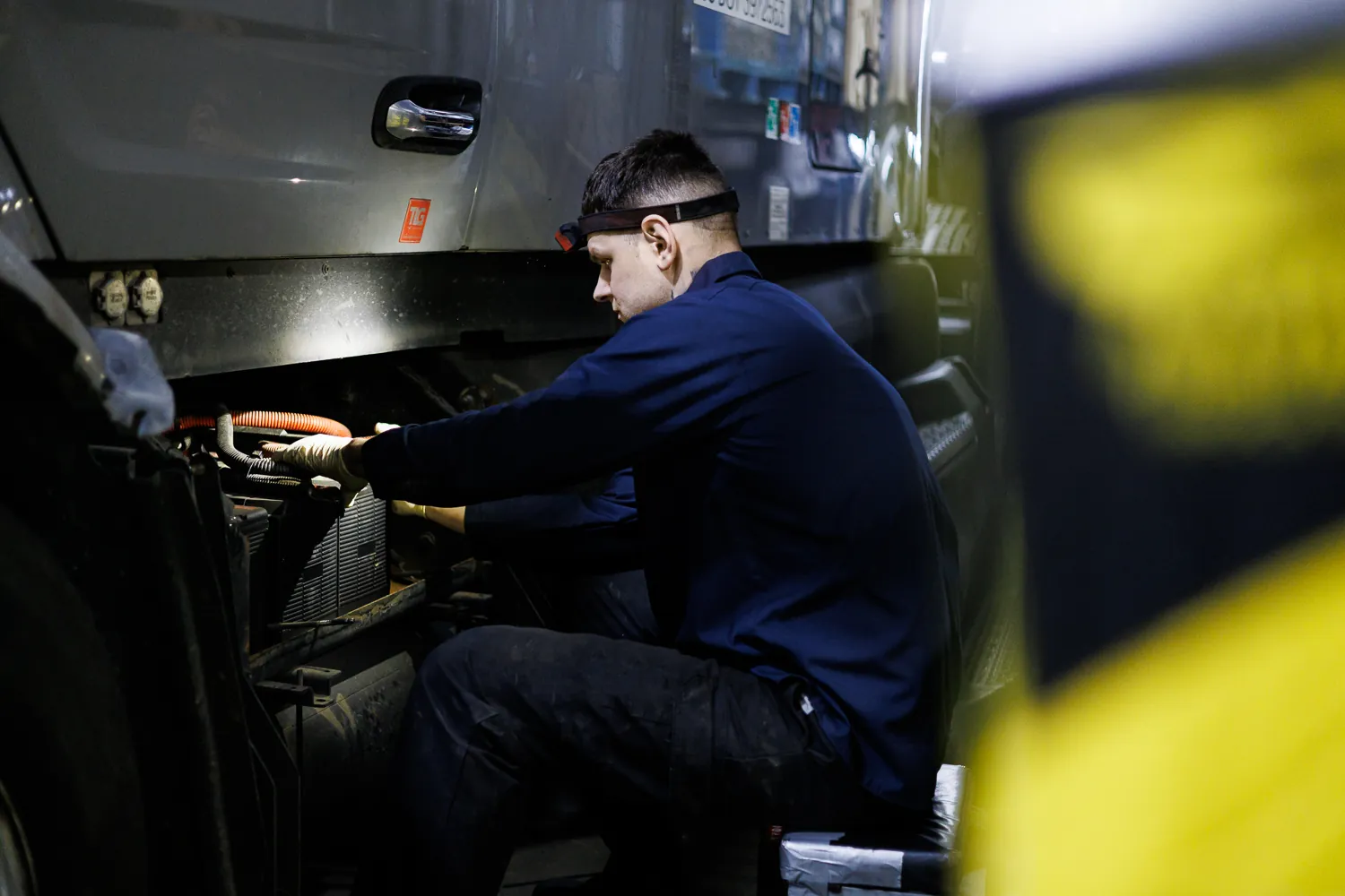 A Truck Clinic technician working on a commercial truck engine